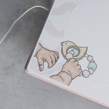 Pink suede baby milestones photo album with a cute illustration of baby hands holding a wooden bird rattle.