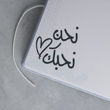 Light blue personalized baby milestones photo album with Arabic calligraphy and a heart design.