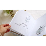 Open personalized baby milestone photo album showing "2 MONTHS" page with moon illustration and space for notes.
