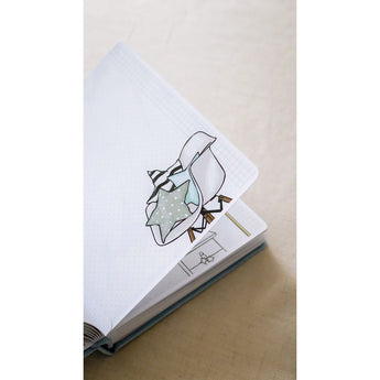 Open personalized baby milestones photo album with a cute baby illustration and grid pages.