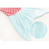 Soft, light blue mermaid tail sleeping sack with pink scales and a close-up of the plush fabric.