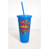 Blue 24oz personalized tumbler with "NABIL" in red, superhero mask, lightning bolts, and shield designs.