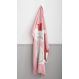 Pink knitted blanket with a white cat wearing a red crown, hanging on a white and gray wall.