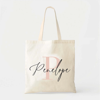 Personalized natural cotton tote bag with a large pink "P" and "Penelope" in black script.