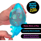 Hand holding a translucent blue NEE DOH Dream Drop squishy fidget toy with glitter.