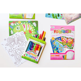 Ooly Foil Tastic art kit with foil sheets, coloring pages featuring butterflies and a chameleon, and scented twist-up crayons.
