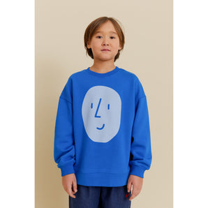 Kid in blue organic cotton oversized sweatshirt with light blue potato face print.