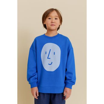Kid in blue organic cotton oversized sweatshirt with light blue potato face print.