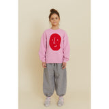 Kid's oversized pink organic cotton sweatshirt with a red potato face print, paired with gingham pants.