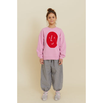 Kid's oversized pink organic cotton sweatshirt with a red potato face print, paired with gingham pants.