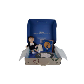 Box containing a plush toy and book with a QR code on a gray background