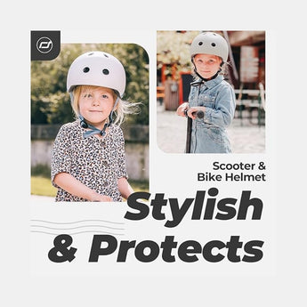 Two young girls wearing light grey Scoot & Ride eco-friendly kids helmets, one smiling at the camera.