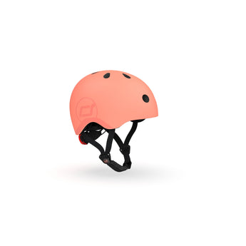 Scoot & Ride eco-friendly kids helmet in matte peach, with black vents and adjustable straps.