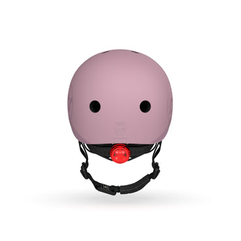 Pink Scoot & Ride kids helmet with a matte finish, black straps, and a bright red rear LED light.