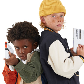 Two kids back-to-back, holding white Sharper Image Handtank laser tag blasters. One wears a yellow beanie.
