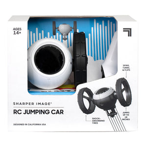 Sharper Image RC Jumping Car in white and black, with shock-absorbing tires, displayed in its retail box.