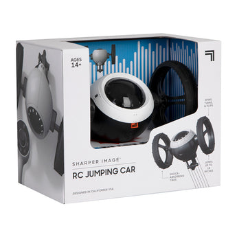 Sharper Image RC Jumping Car toy in its white and blue retail box, featuring a black and white vehicle with large wheels.