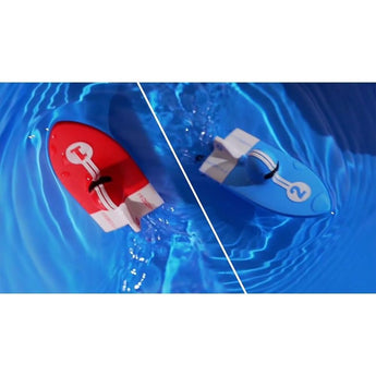 Two Sharper Image Remote Control Hydro Park Racers, one red with "1" and one blue with "2", floating in water.