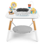 White Skip Hop Discoverosity 3 Stage Activity Center with colorful toys, wooden legs, and gray seat.