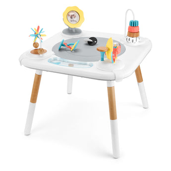 White Skip Hop Discoverosity 3 Stage Activity Center with wooden legs and colorful developmental toys.