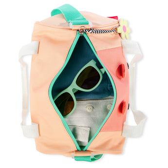 Peach Skip Hop Duffimals kids duffle bag with mint zipper, white handles, and sunglasses inside.