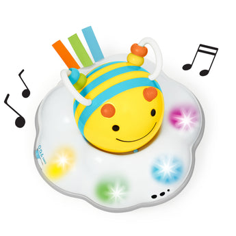Yellow and blue striped Skip Hop Follow Bee crawl toy on a white cloud base with colorful lights and music notes.