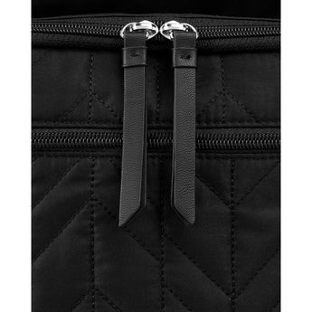 Close-up of a black quilted Skip Hop Forma backpack with two silver zippers and black faux leather pulls.