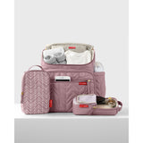 Pink quilted Skip Hop Forma backpack nappy bag, open with baby essentials and two patterned packing cubes.
