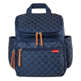 Navy blue quilted Skip Hop Forma backpack nappy bag with tan zipper pulls and side pockets.