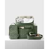 Olive green quilted Skip Hop Forma backpack with packing cubes, baby clothes, and bottle.