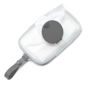 Clear Skip Hop Grab & Go wipes case with a dark gray lid and strap, holding white baby wipes.