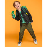 Smiling boy holds a green Skip Hop stainless steel straw water bottle with a soccer ball design.