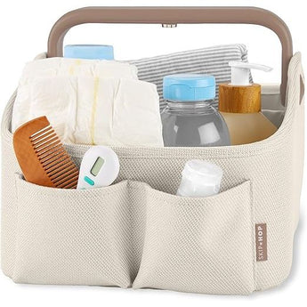 Skip Hop Light Up Diaper Caddy in beige fabric with brown handle, filled with baby essentials.