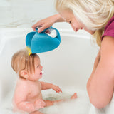 Blonde woman rinsing baby's hair with a blue whale-shaped Skip Hop Moby Waterfall Rinser in a white bathtub.