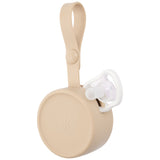 Skip Hop beige silicone pacifier holder with a white pacifier peeking out, featuring a strap for attachment.
