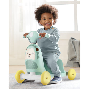 Happy toddler on a mint green Skip Hop Zoo 3-in-1 ride-on toy with yellow wheels, designed as a hedgehog.