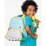 Smiling toddler with a light blue Skip Hop Zoo shark backpack and matching water bottle.