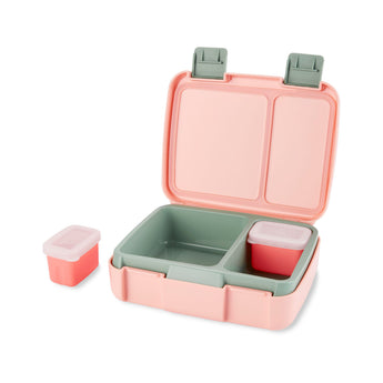Open Skip Hop Zoo bento box with pink exterior, green interior, two compartments, and two small lidded containers.