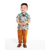 Smiling toddler boy wearing a green Skip Hop Zoolet Bee mini backpack with a detachable tether.