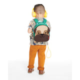 Toddler wearing a Skip Hop Zoolet Pug Mini Backpack with a brown pug face, green trim, and yellow headphones.