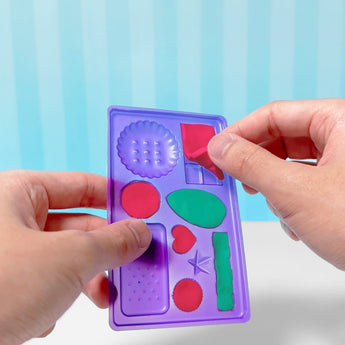 Hands pressing colorful slime into a purple Slimy Gelateria mold with various shapes.
