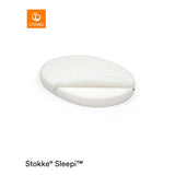 White Stokke Sleepi Mini oval polyurethane foam mattress with quilted cover, partially unzipped.