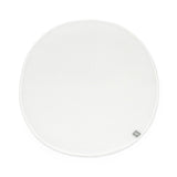 White circular Stokke Sleepi Mini polyurethane foam mattress pad with subtle texture and small gray brand tag.