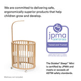 White Stokke Sleepi Mini Mattress in a natural wood crib, JPMA certified.