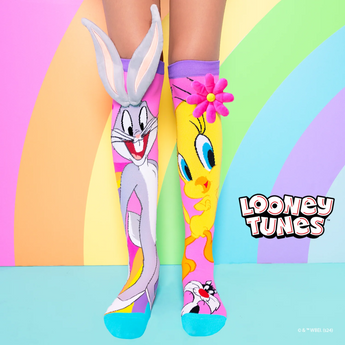 Colorful socks with cartoon characters on a pastel rainbow background, featuring the Looney Tunes logo.