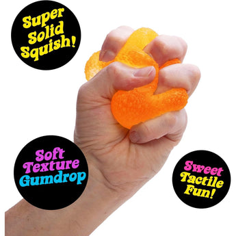 Hand squeezing an orange, textured NEE DOH Gumdrop squishy fidget toy.